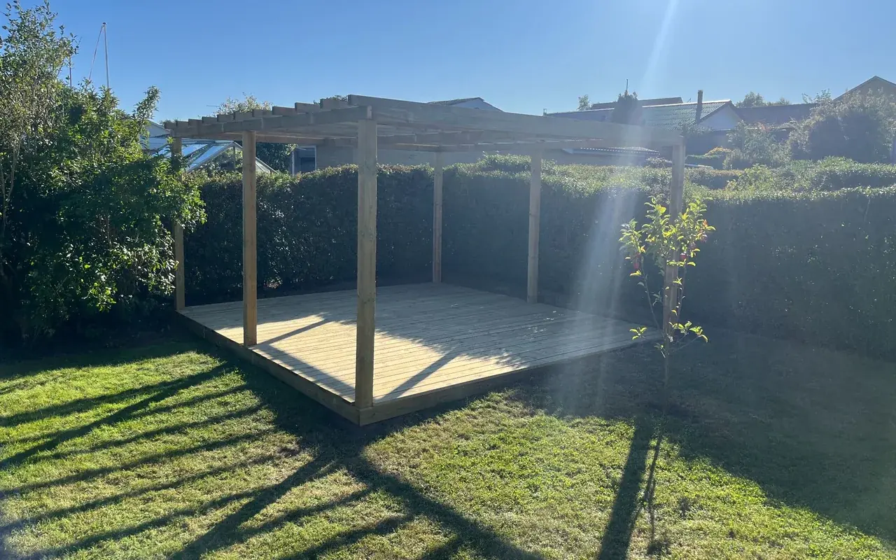 Træterrasse med pergola bygget i en have